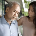 Caregiver assisting senior man, emphasizing compassionate support and personalized home care services in Sarasota for dementia care.