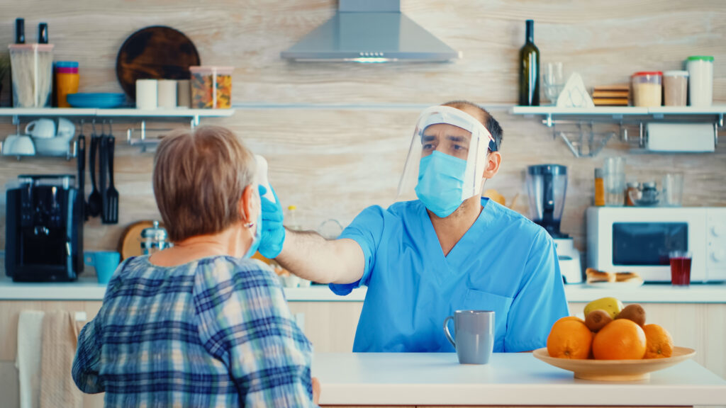 n-home caregiver checking temperature of senior woman – personalized home care services"