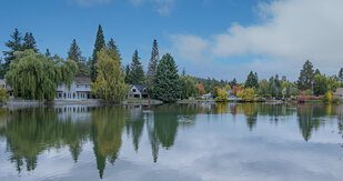Scenic view of serene lake surrounded by lush greenery, reflecting the sky, representing peaceful living and independence in home care settings.