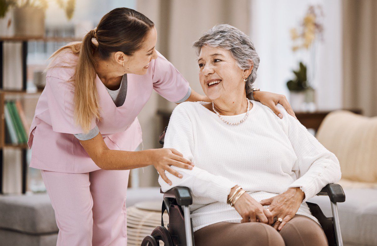 Caregiver providing support to elderly individual in a home setting, emphasizing companionship and personalized care for those with chronic illnesses or cognitive decline.